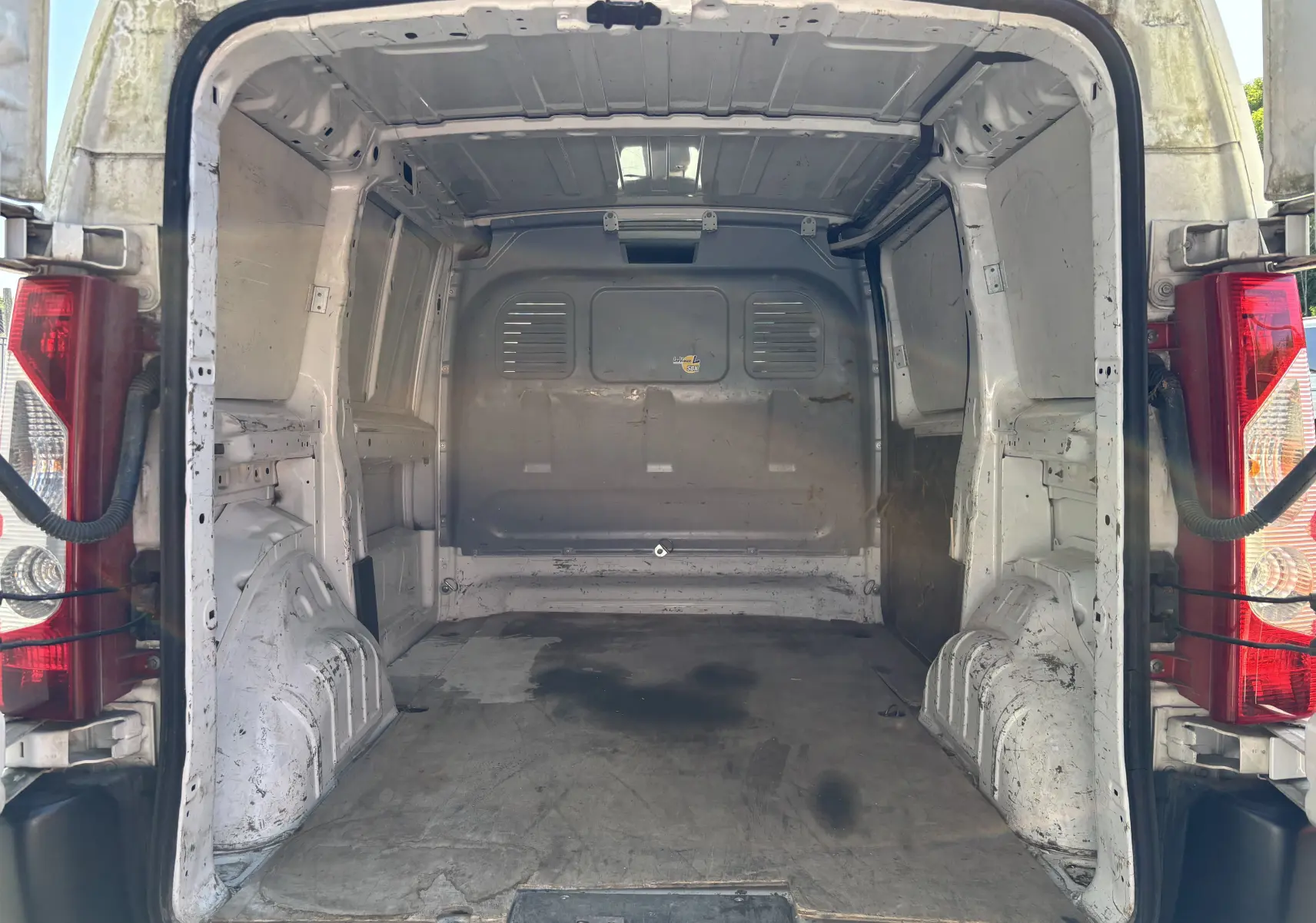 Vue arrière du fourgon blanc FIAT Scudo II 1.6 MJTD 90CV de 2010, montrant l'espace de chargement vide et usé.