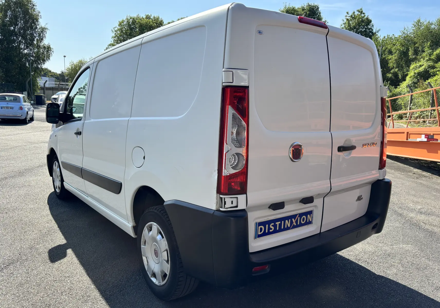 Fiat Scudo Fourgon blanc vu en 3/4 arrière droit, avec portes arrière fermées et pare-chocs noirs visibles.