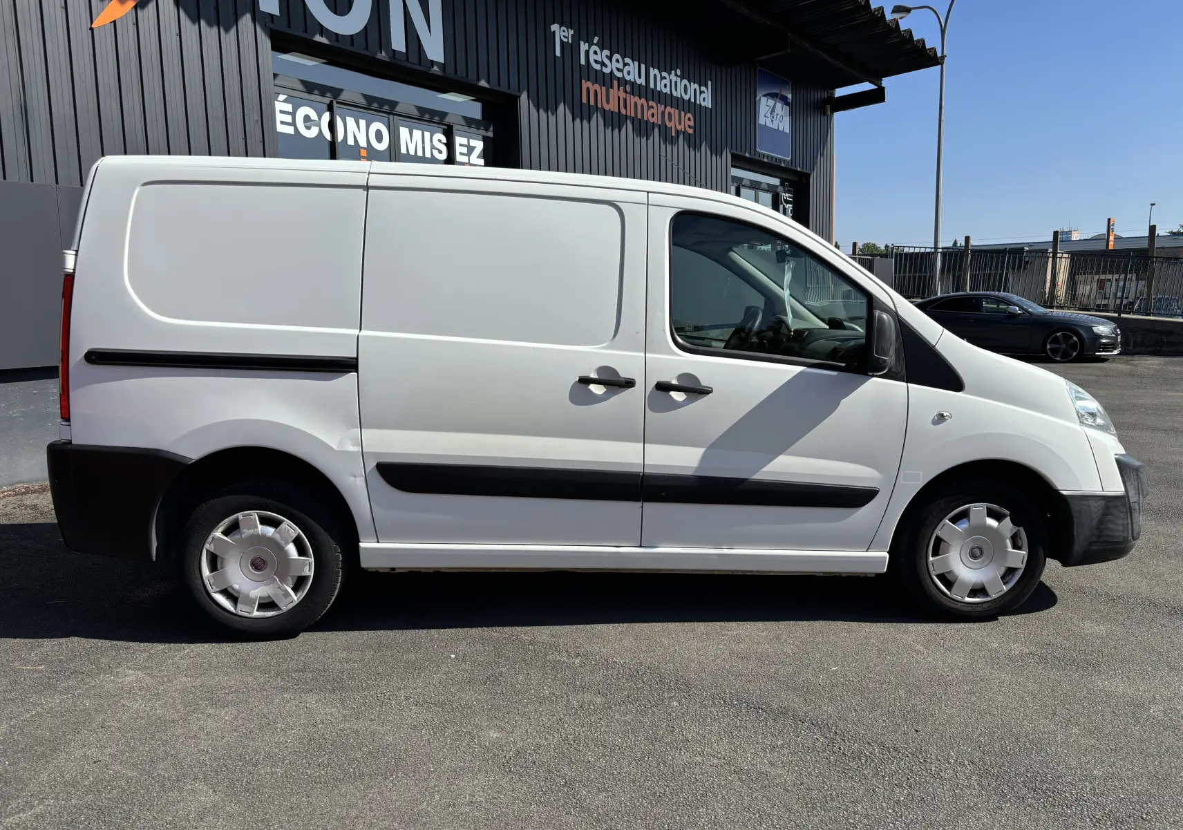 Fiat Scudo Fourgon blanc vu de profil côté gauche, avec portes latérales et jantes acier d'origine.