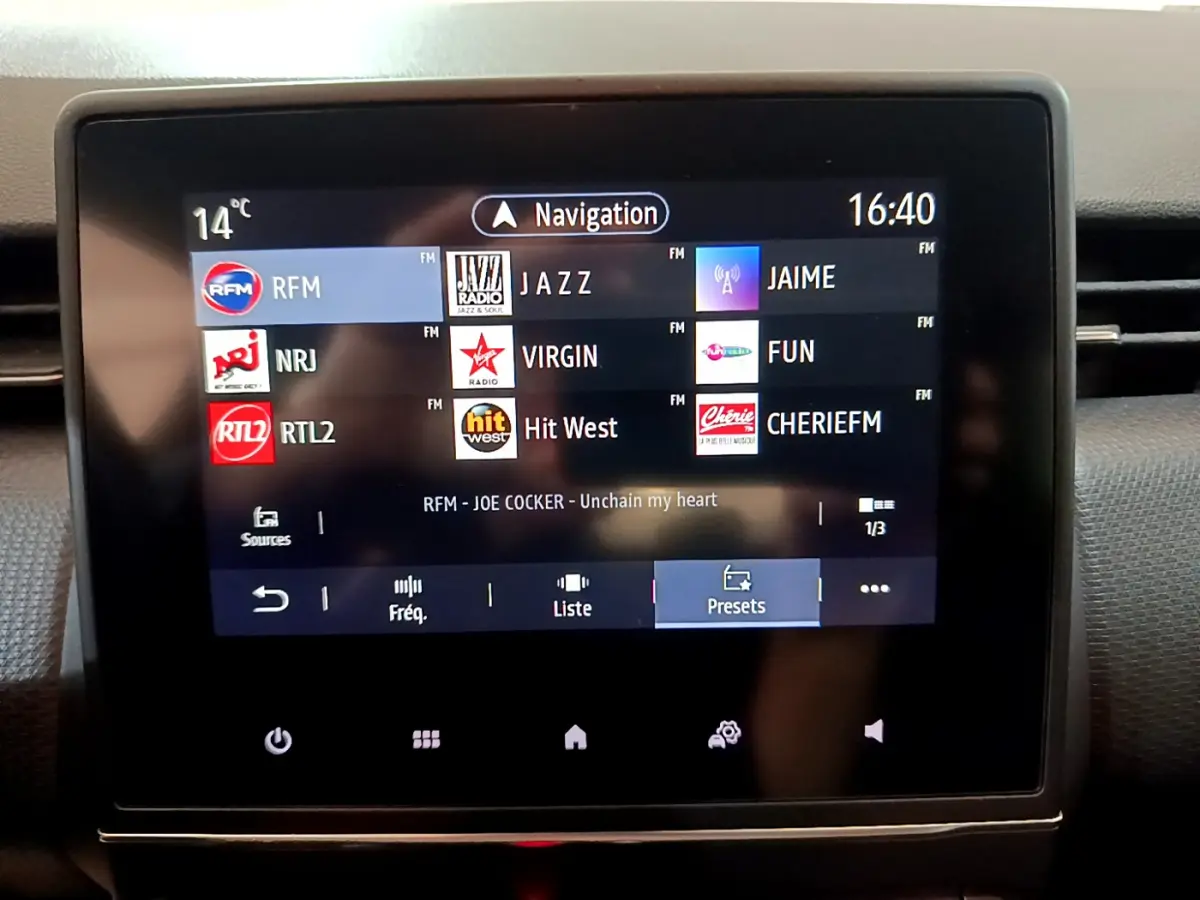 Écran tactile central de la Renault Clio Business blanc 2021 affichant les stations radio FM et la navigation à 16h40.