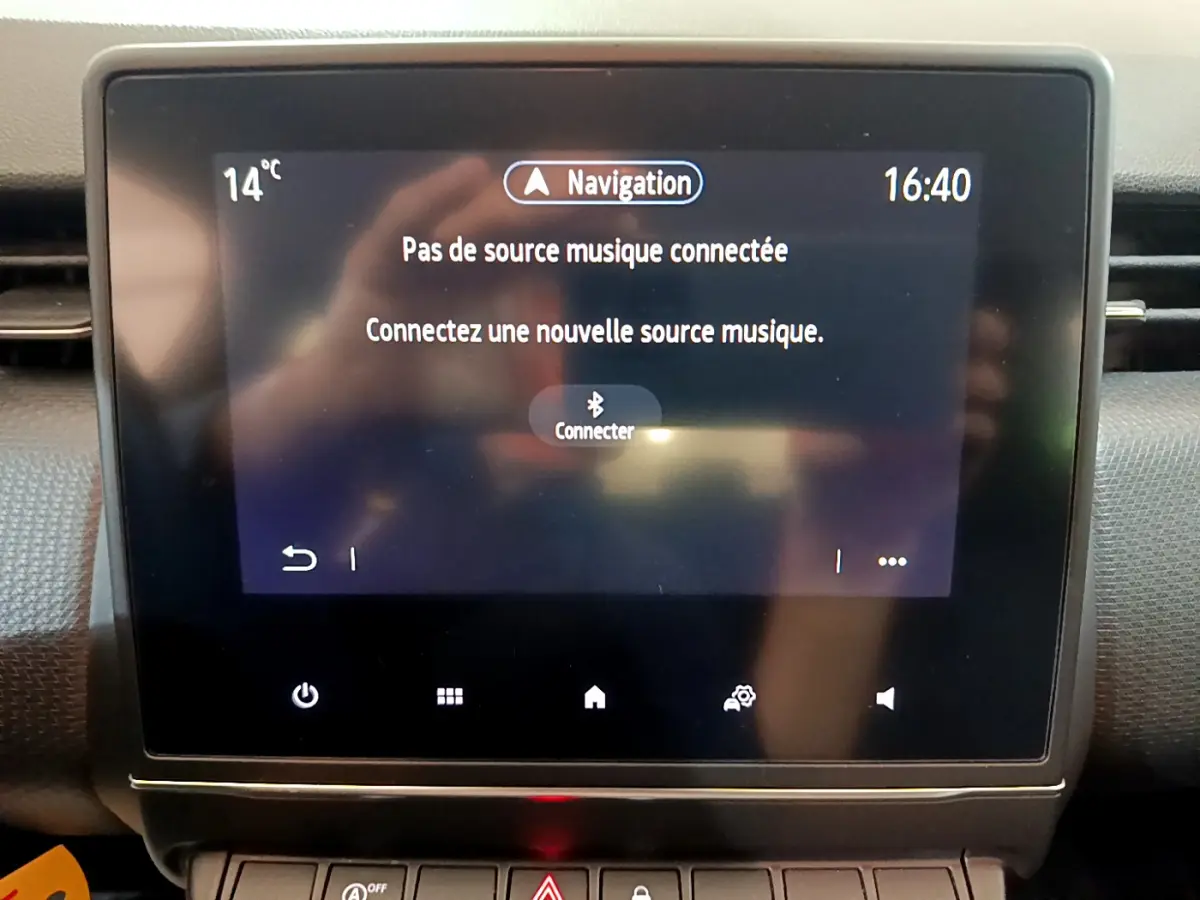Écran tactile central de la Renault Clio Business blanc 2021 affichant un message de connexion Bluetooth pour la musique.