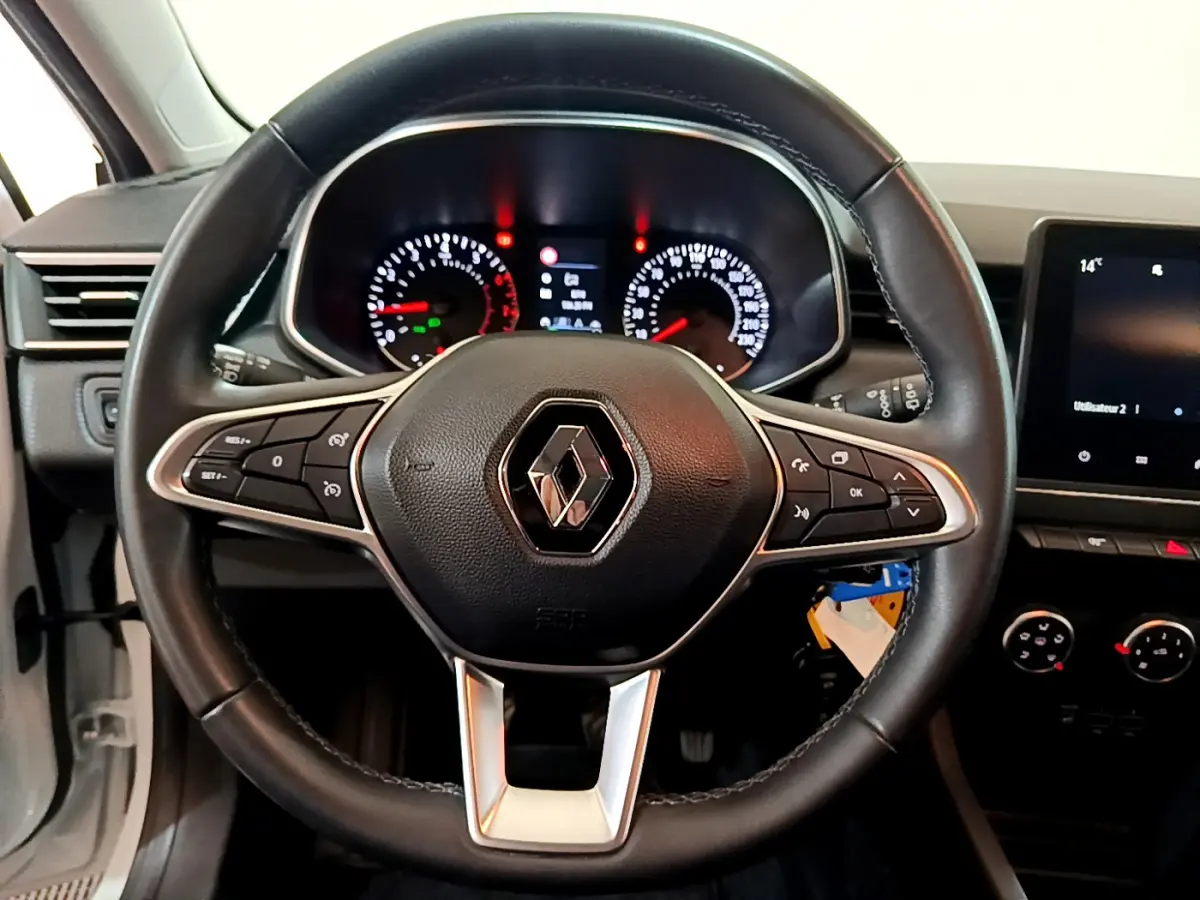 Vue centrée sur le volant cuir noir de la Renault Clio Business 2021 avec tableau de bord et écran tactile visibles.