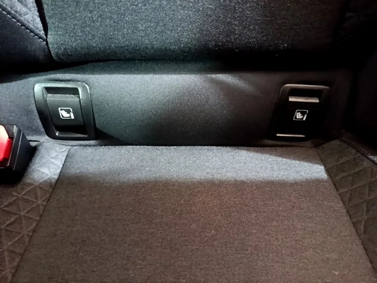 Gros plan sur la banquette arrière noire de la Renault Clio Business avec les attaches Isofix visibles.