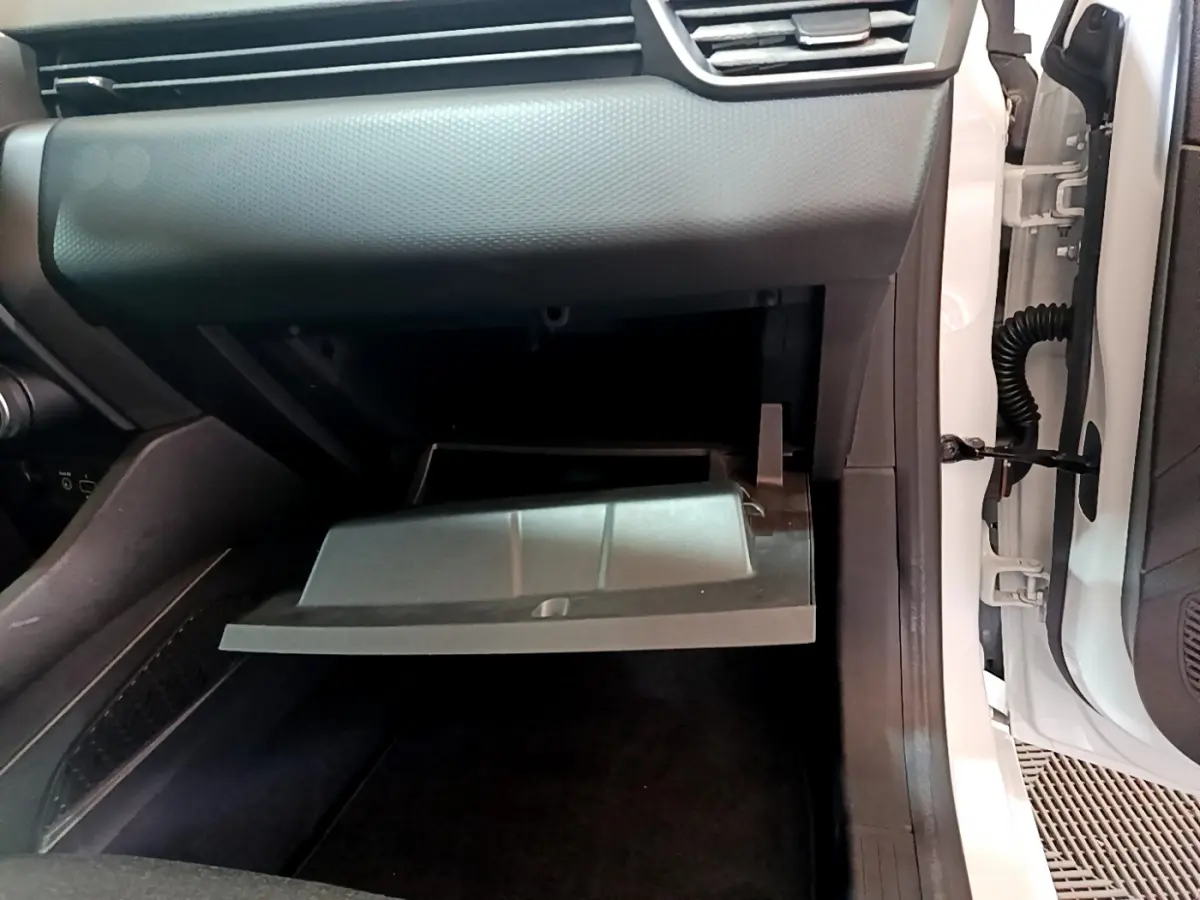 Vue intérieure côté passager de la boîte à gants ouverte dans une Renault Clio Business blanche de 2021.