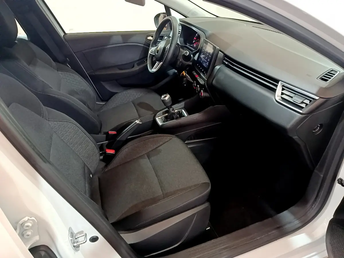 Intérieur de la Renault Clio Business blanche 2021 vu côté conducteur, avec sièges noirs et écran tactile central.