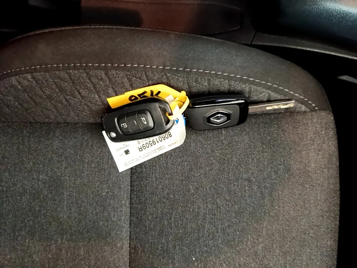 Clé Renault posée sur un siège tissu gris foncé à l'intérieur d'une Clio Business blanche 2021.