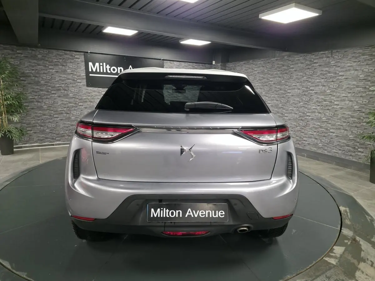 Vue arrière d'un DS3 Crossback gris métallisé avec feux arrière LED et canule d'échappement chromée visible.