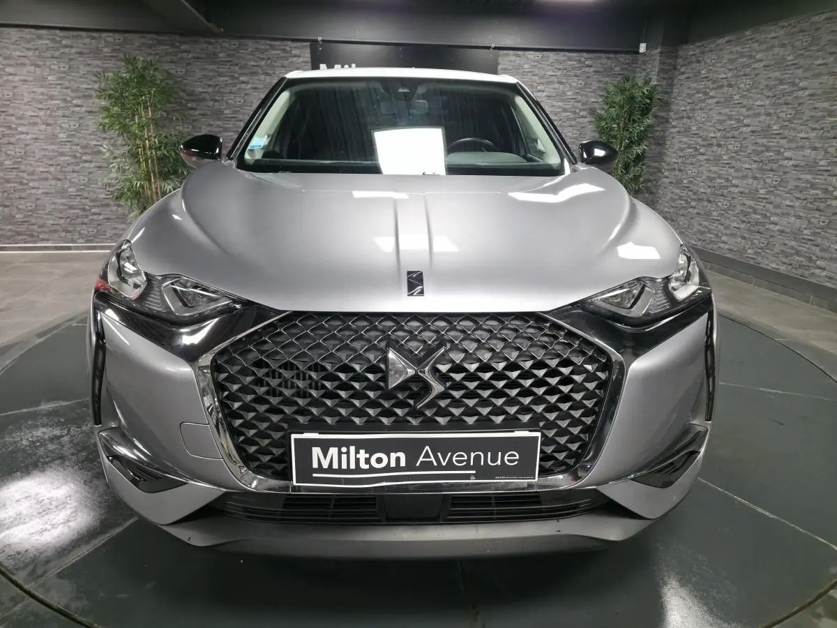 Vue frontale du DS3 Crossback gris métallisé avec calandre noire texturée et logo DS visible au centre.