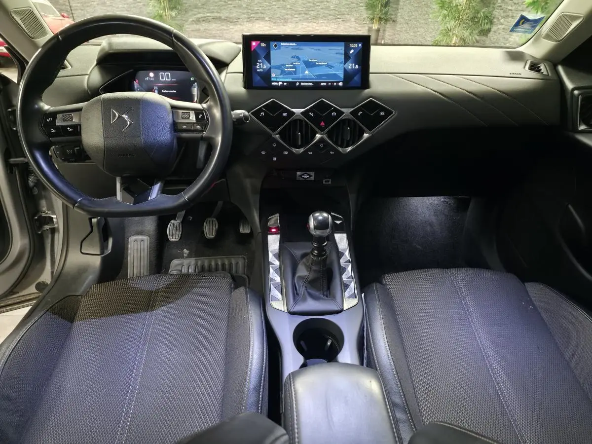 Vue intérieure avant du DS3 Crossback 2022 montrant le volant cuir, la console centrale avec levier de vitesses manuel et l'écran tactile.