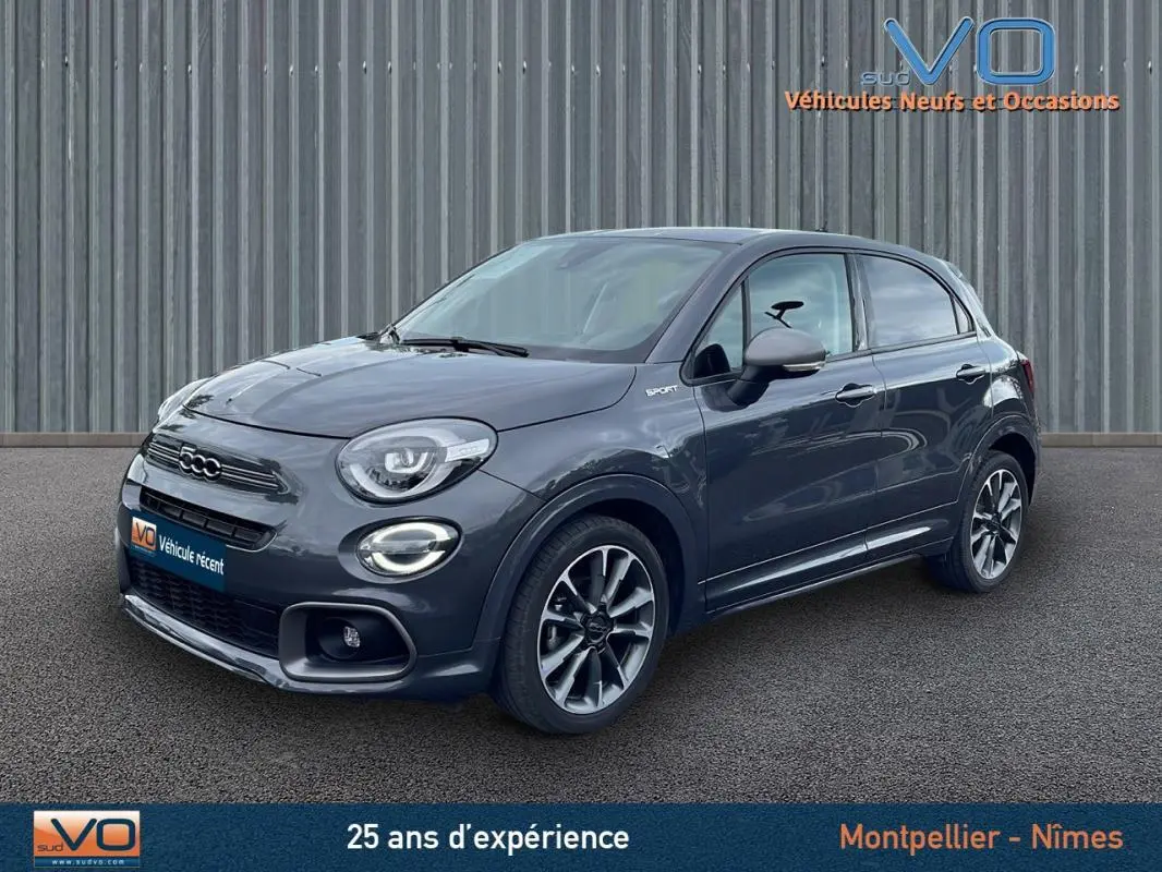 Vue 3/4 avant d'une FIAT 500X MY22 gris foncé avec jantes alliage 18 pouces et badge Sport sur le côté droit.