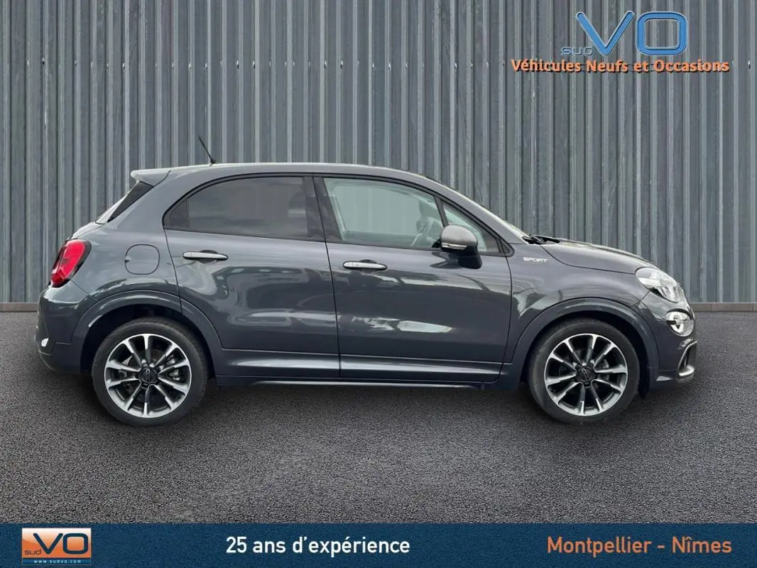 Profil côté gauche d'une FIAT 500X gris métallisé version Sport avec jantes alliage 18 pouces sur fond urbain.