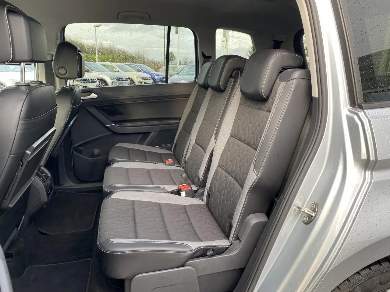 Vue intérieure côté droit sur les sièges arrière gris foncé avec surpiqûres du Volkswagen Touran Oyster Argent métallisé.