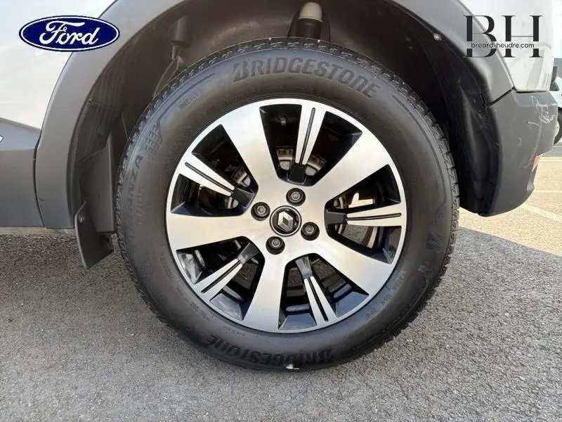 Gros plan sur la roue avant gauche du Renault Captur gris Platine, mettant en valeur la jante alliage et le pneu Bridgestone.