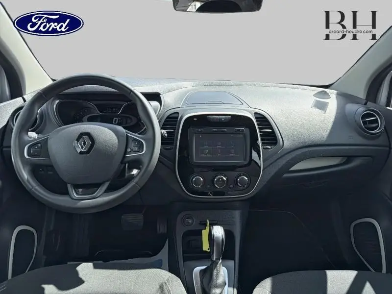 Vue intérieure avant du tableau de bord et volant gris d'une Renault Captur 2018 avec écran tactile et boîte automatique.