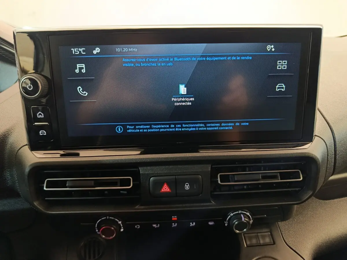 Vue rapprochée de l’écran tactile central et des commandes de climatisation du Peugeot Partner blanc 2026.