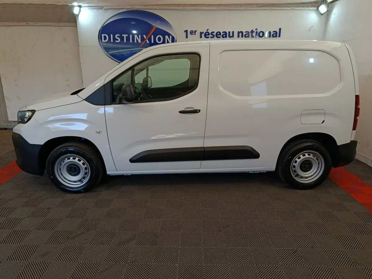 Vue de profil côté gauche d’un utilitaire Peugeot Partner blanc, version Taille M, avec jantes acier et protections latérales noires.