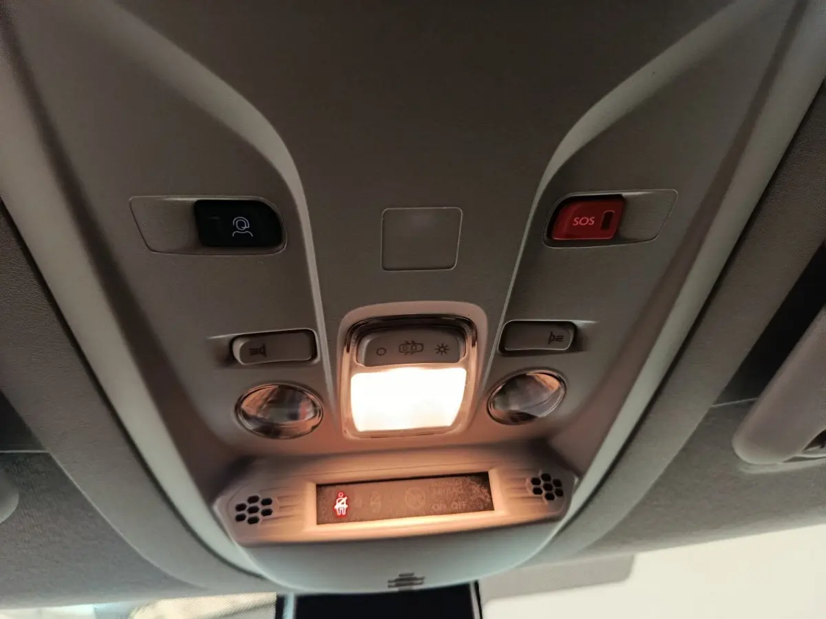 Vue intérieure en plongée sur le plafonnier avec éclairage et bouton SOS du Peugeot Partner blanc 2026.
