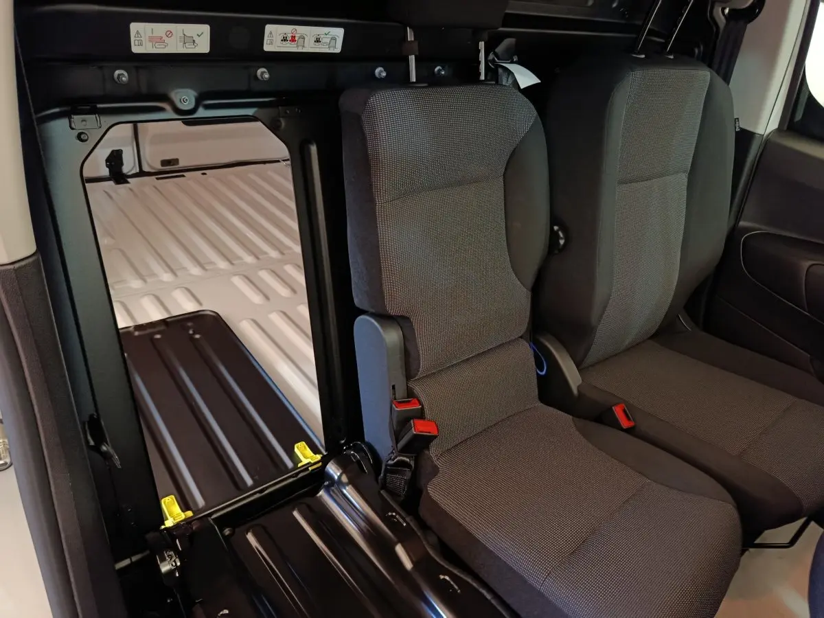 Vue intérieure montrant les sièges avant gris et la cloison pleine blanche du Peugeot Partner Taille M 650kg 2026.