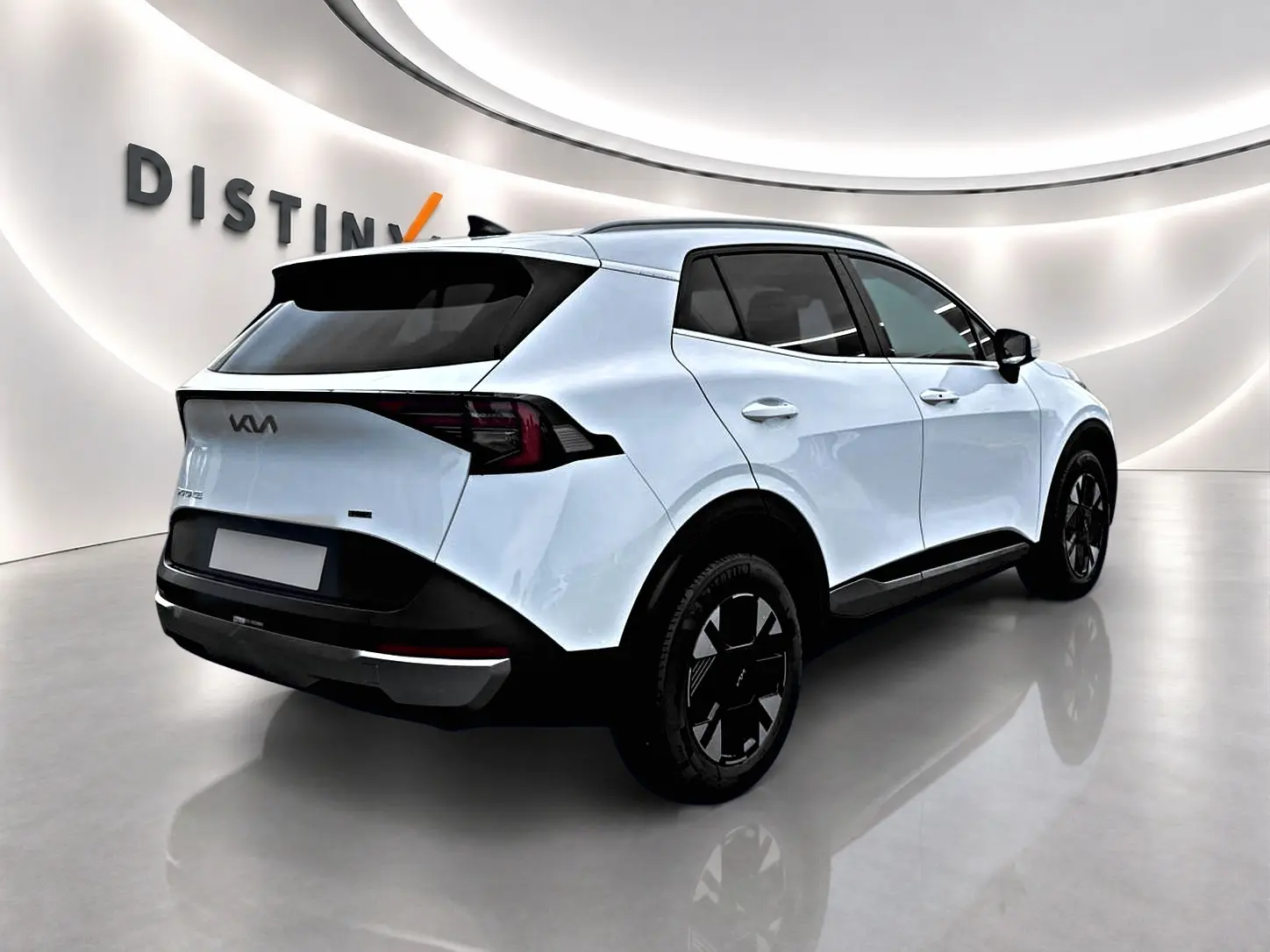 Vue 3/4 arrière droite d'un KIA Sportage blanc 2026 avec jantes noires et feux arrière LED distinctifs.
