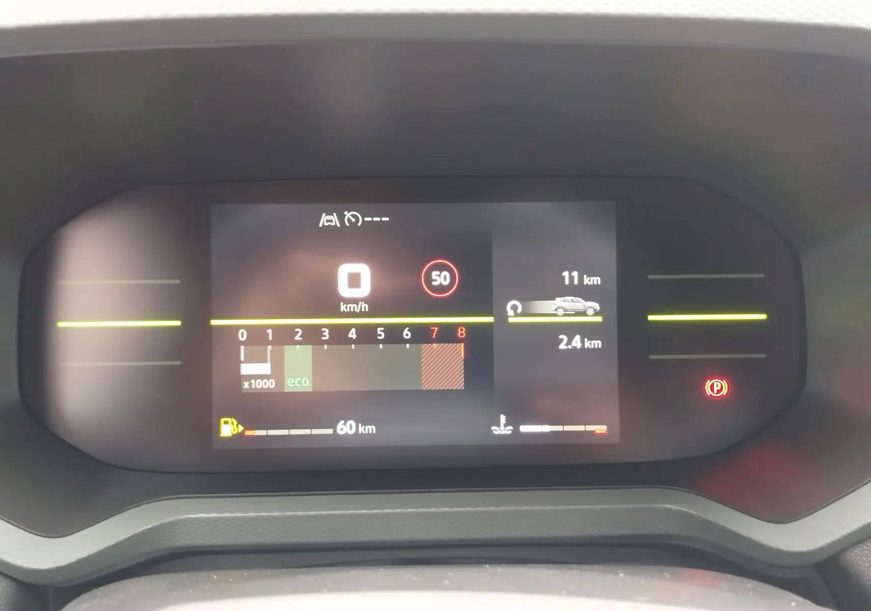 Tableau de bord numérique du Dacia Duster gris schiste 2025 affichant vitesse, régime moteur et autonomie restante.