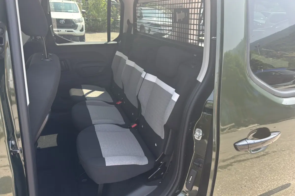 Vue côté droit de l'intérieur arrière d'un Citroën Berlingo Sirkka green avec trois sièges indépendants gris et noirs.