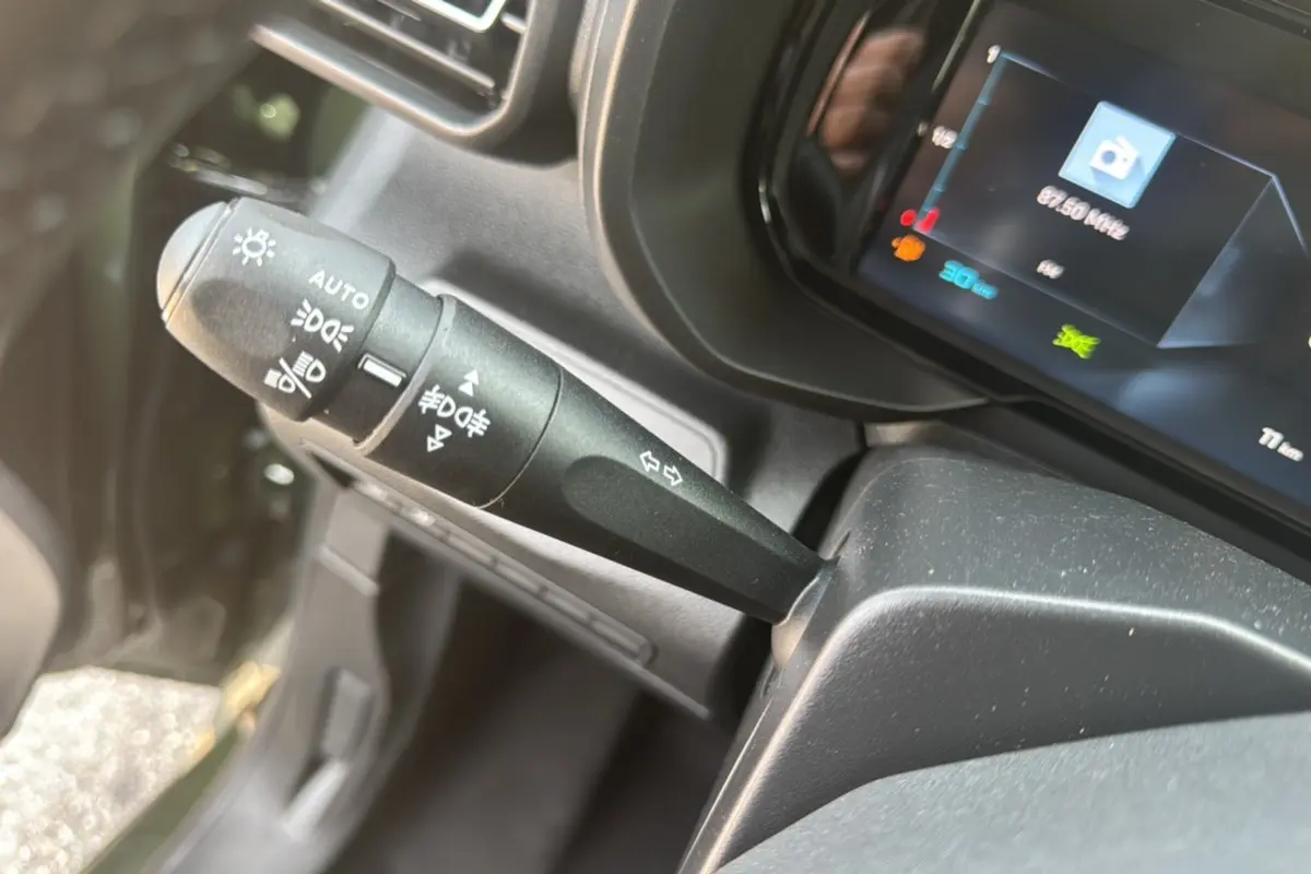 Gros plan sur la commande des feux et clignotants du Citroën Berlingo BlueHDi 130 EAT8 Max, intérieur noir.