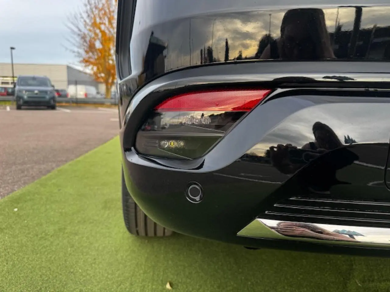 Gros plan sur le feu arrière droit du Renault Espace VI noir étoilé, avec capteur de stationnement intégré.