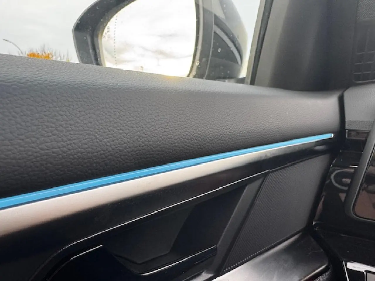 Détail de la porte côté gauche de la Renault Espace 2025 noir étoilé avec bande lumineuse bleue intérieure.