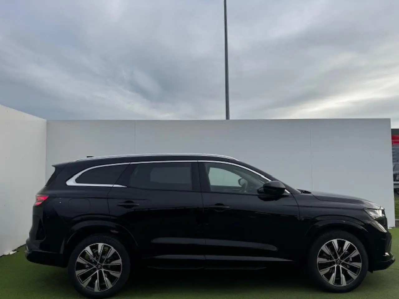 Profil côté gauche du Renault Espace VI noir étoilé avec jantes alliage diamantées et vitres surteintées.