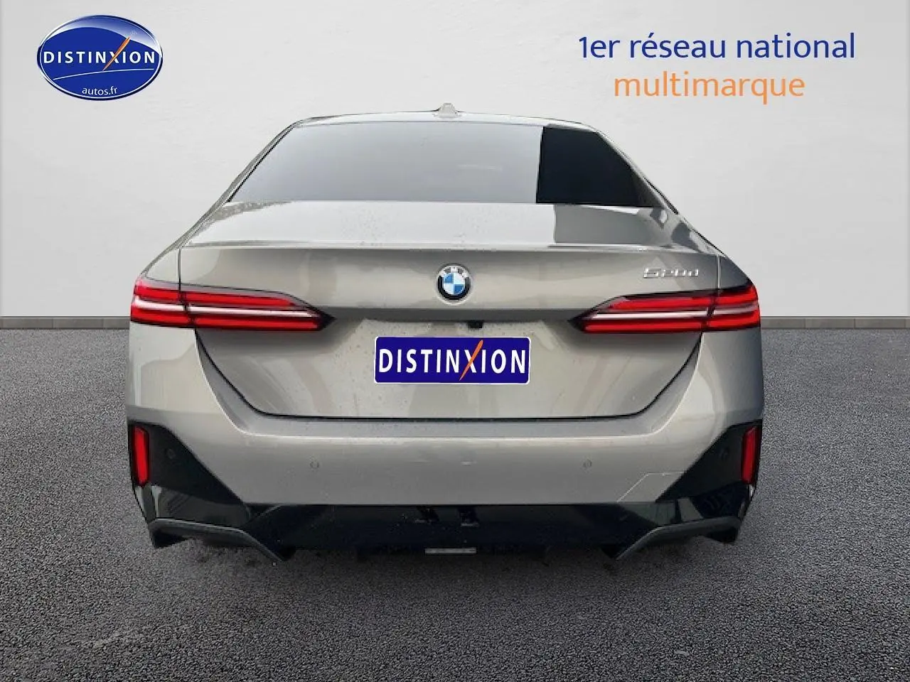 Vue arrière d'une BMW Série 5 520da gris avec feux LED et logo distinctif sur fond neutre.