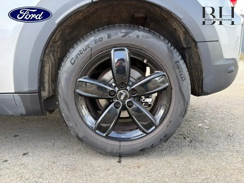 Gros plan sur la roue arrière droite d'une MINI Countryman Melting Silver III avec jante alu noire brillante.