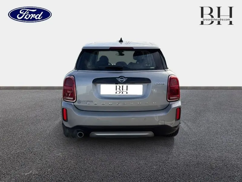 Vue arrière d'une MINI COUNTRYMAN Cooper 136ch Essential 2023 en Melting Silver III avec feux arrière LED et sortie d'échappement chromée.