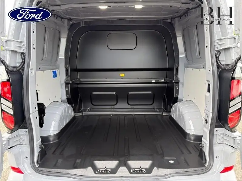 Vue intérieure arrière du fourgon Ford Transit Custom gris Matter Spéciale, montrant l'espace de chargement vide avec plancher noir.