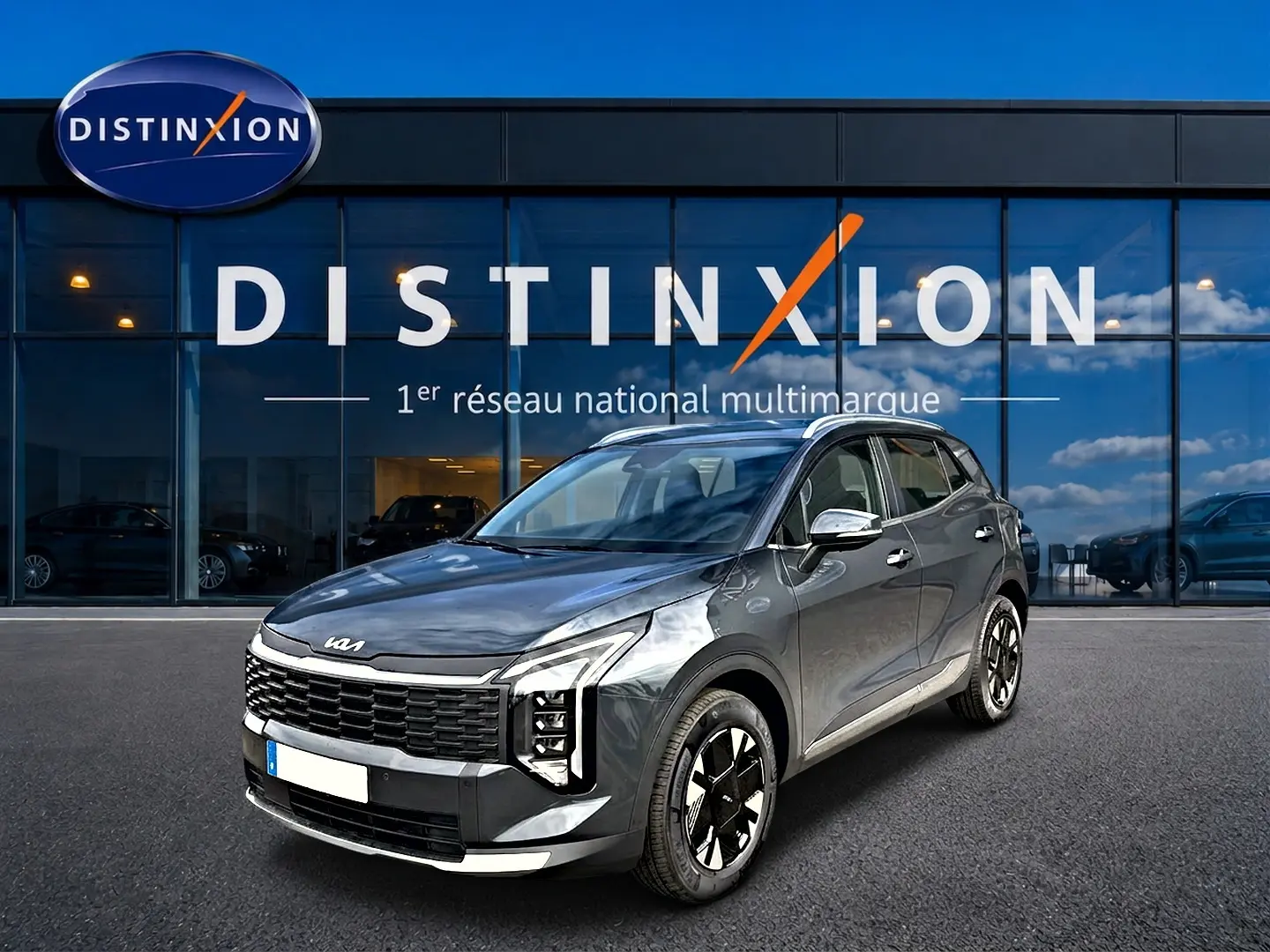 KIA Sportage 1.6 hybride gris eclipse en 3/4 avant droit, avec calandre noire distinctive et jantes alu 17 pouces.