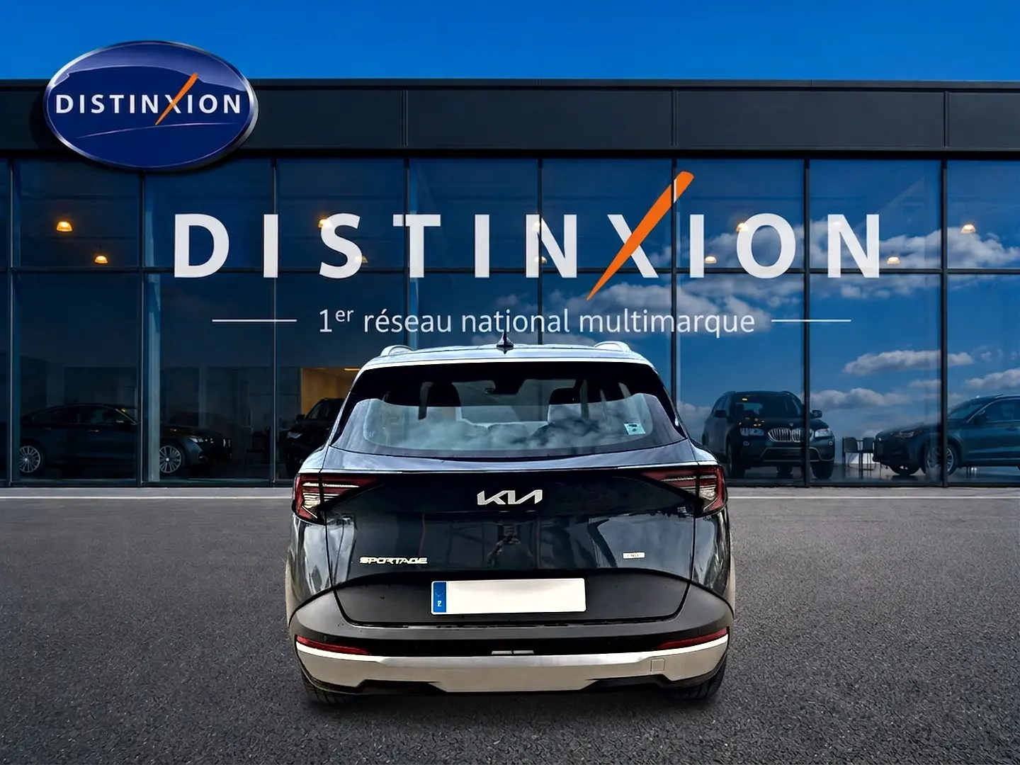 Vue arrière du KIA SPORTAGE 1.6 hybride 239 gris eclipse, avec feux arrière LED et barres de toit visibles.