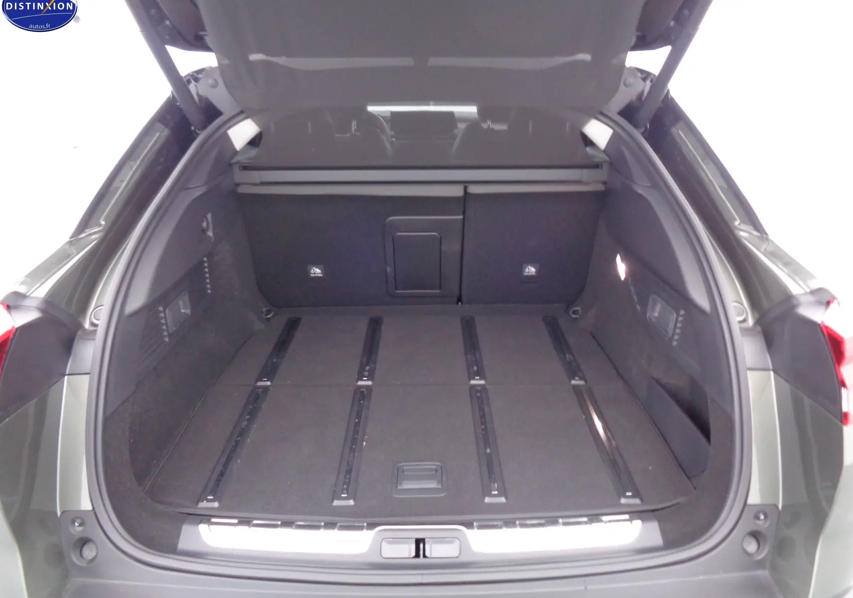 Coffre ouvert en vue arrière d'une Citroën C5 X gris Smart, montrant un grand espace de chargement plat et modulable.