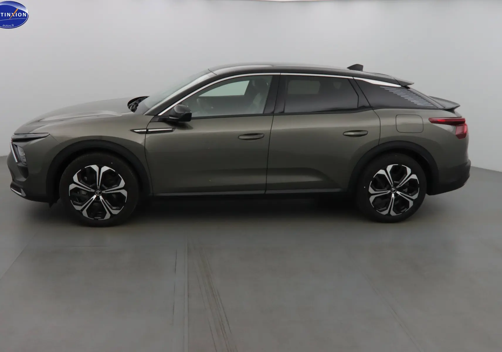 Profil côté gauche d'une Citroën C5 X hybride rechargeable gris smart avec jantes noires et toit noir contrasté.
