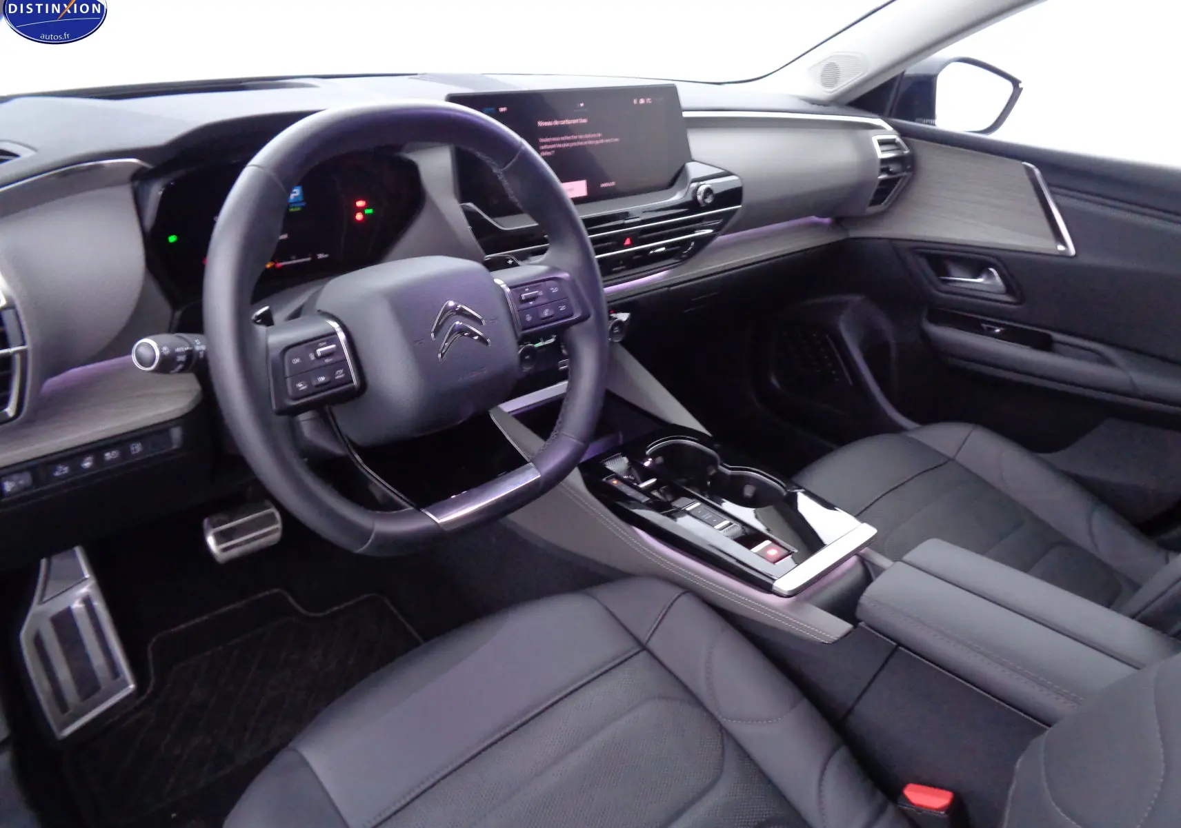 Intérieur avant droit du Citroën C5 X hybride rechargeable 2022, avec tableau de bord moderne et sellerie cuir noir.