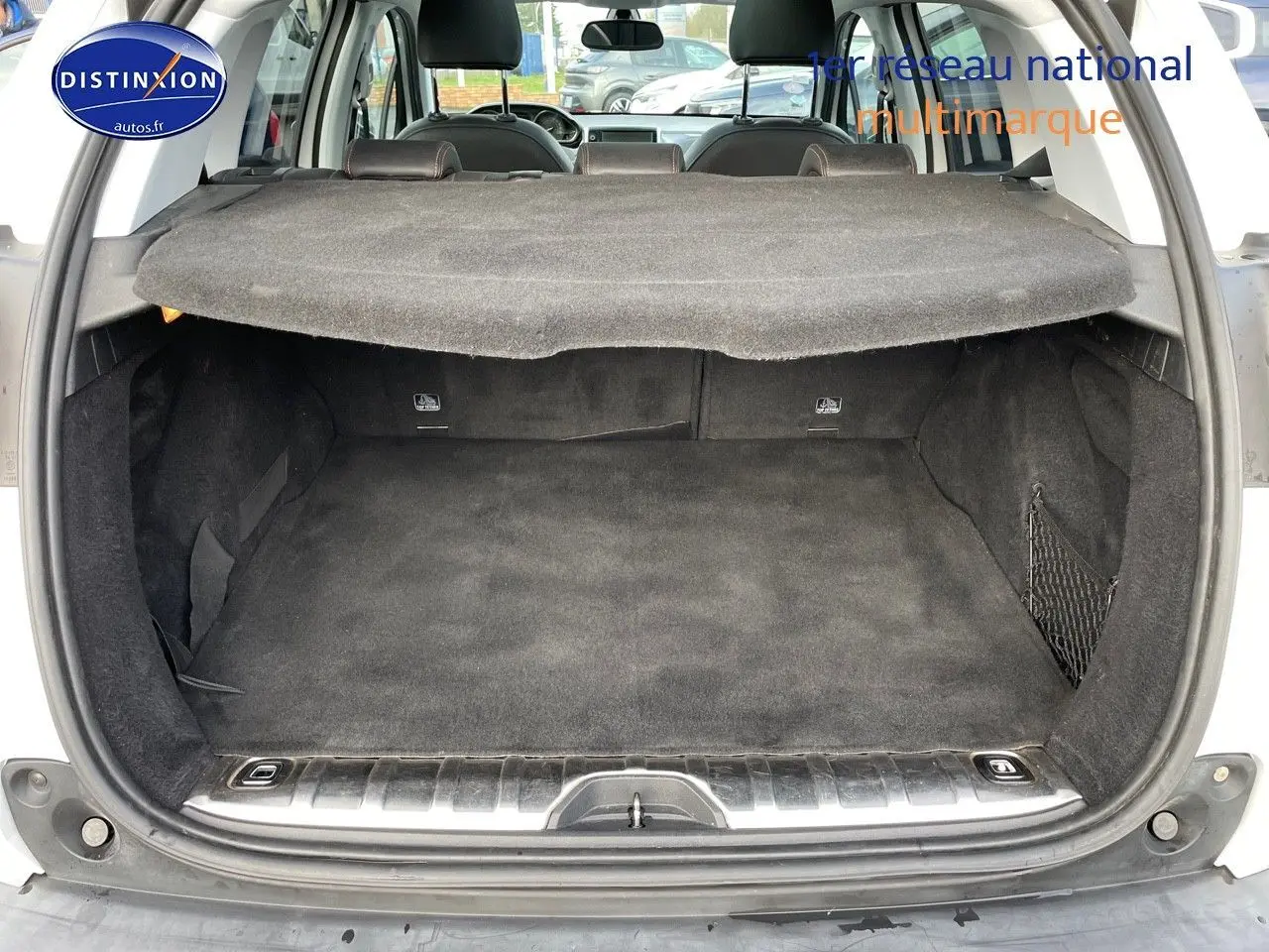 Coffre ouvert d'un Peugeot 2008 blanc de 2016, montrant un espace de chargement propre et bien fini.