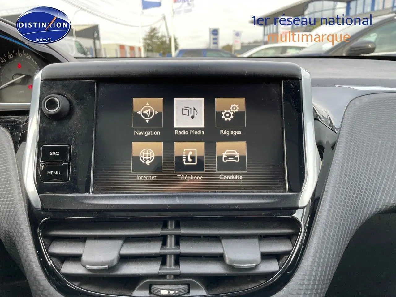 Écran tactile central du tableau de bord du Peugeot 2008 blanc de 2016, affichant les options de navigation et média.