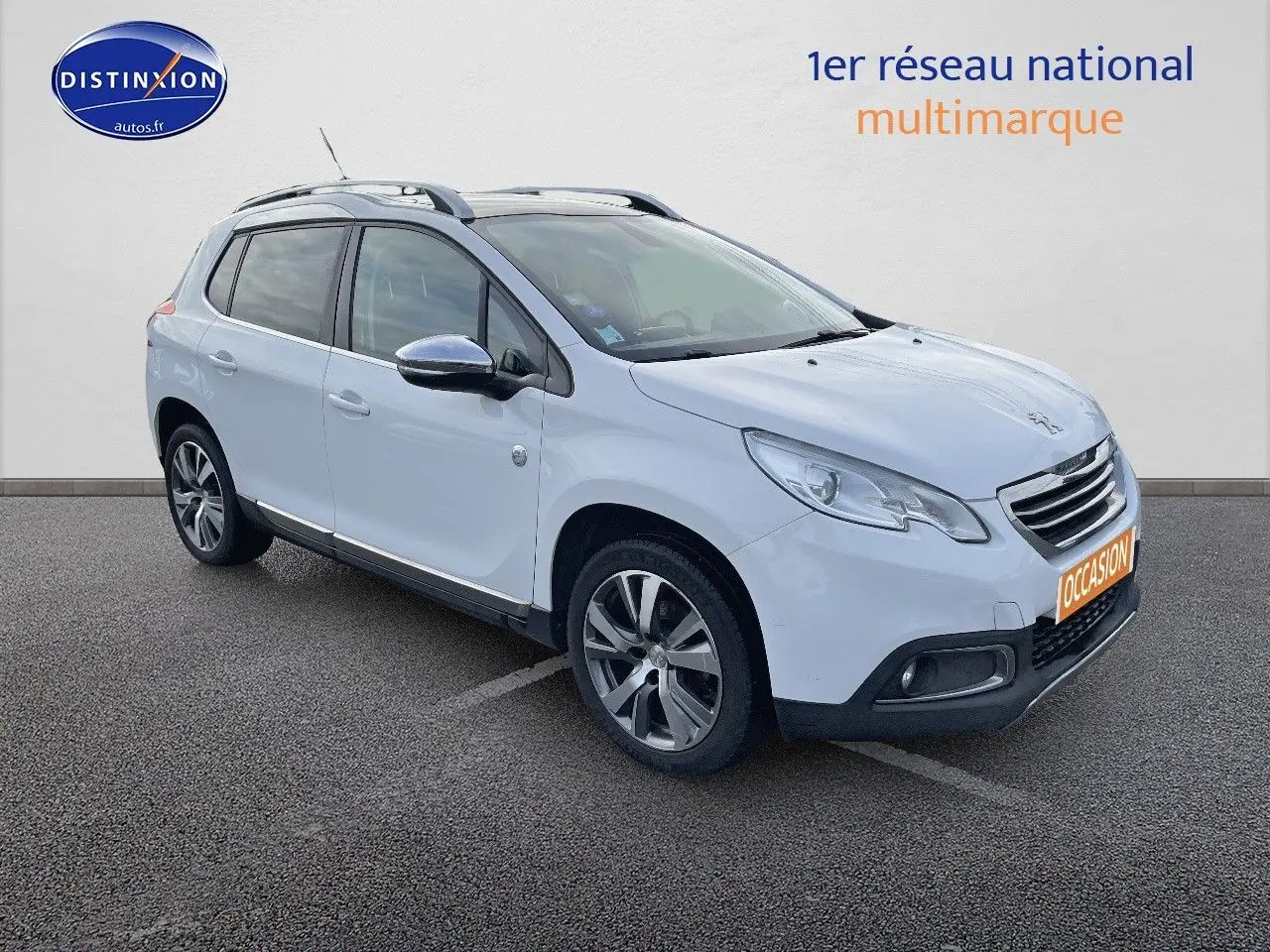 Peugeot 2008 blanc en 3/4 avant droit, avec jantes alliage et barres de toit visibles sur parking.