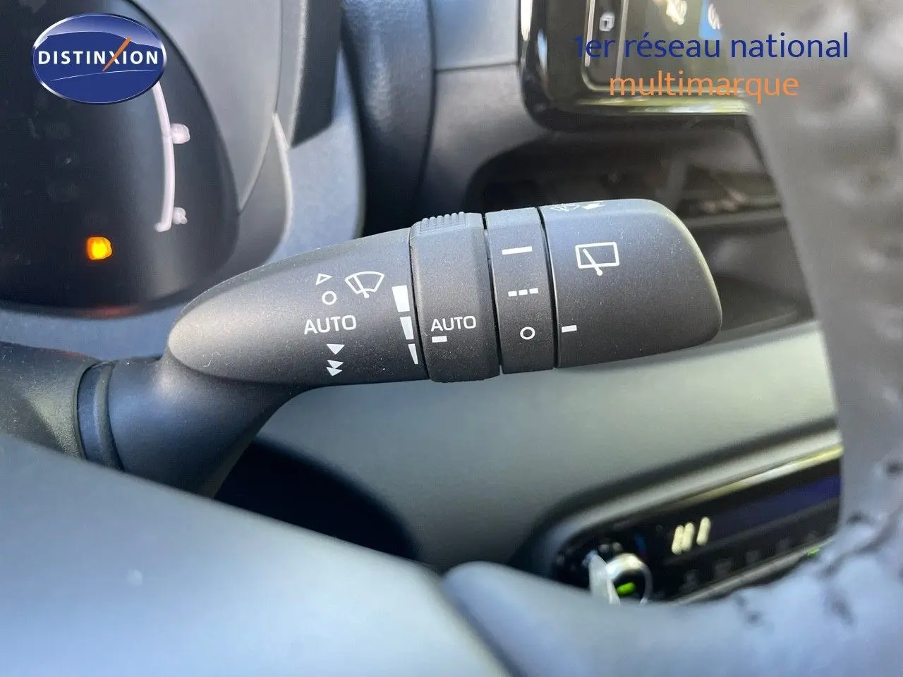 Gros plan sur la commande d'essuie-glace automatique dans l'habitacle d'une Toyota Yaris Hybrid 116ch 2025 noir métal.