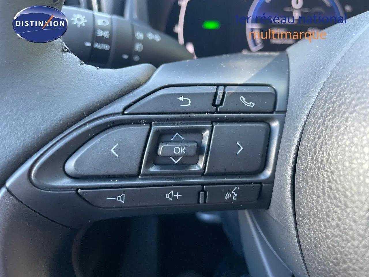 Gros plan sur les commandes multifonctions noires au volant de la Toyota Yaris Hybrid 2025, côté gauche.