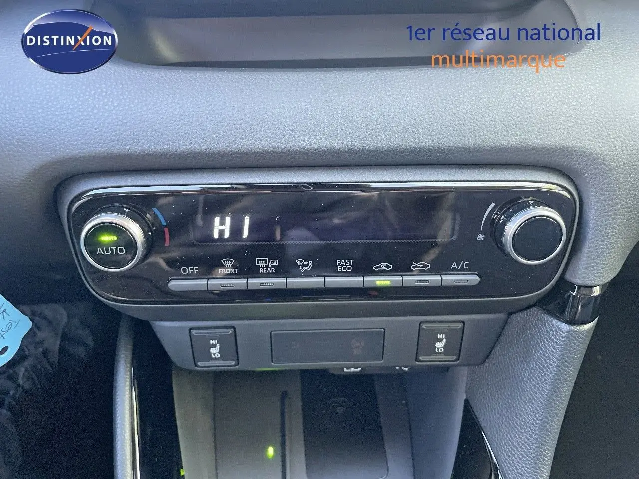 Panneau de commande de climatisation de la Toyota Yaris Hybrid 2025 en noir métal, affichant température haute et sièges chauffants.