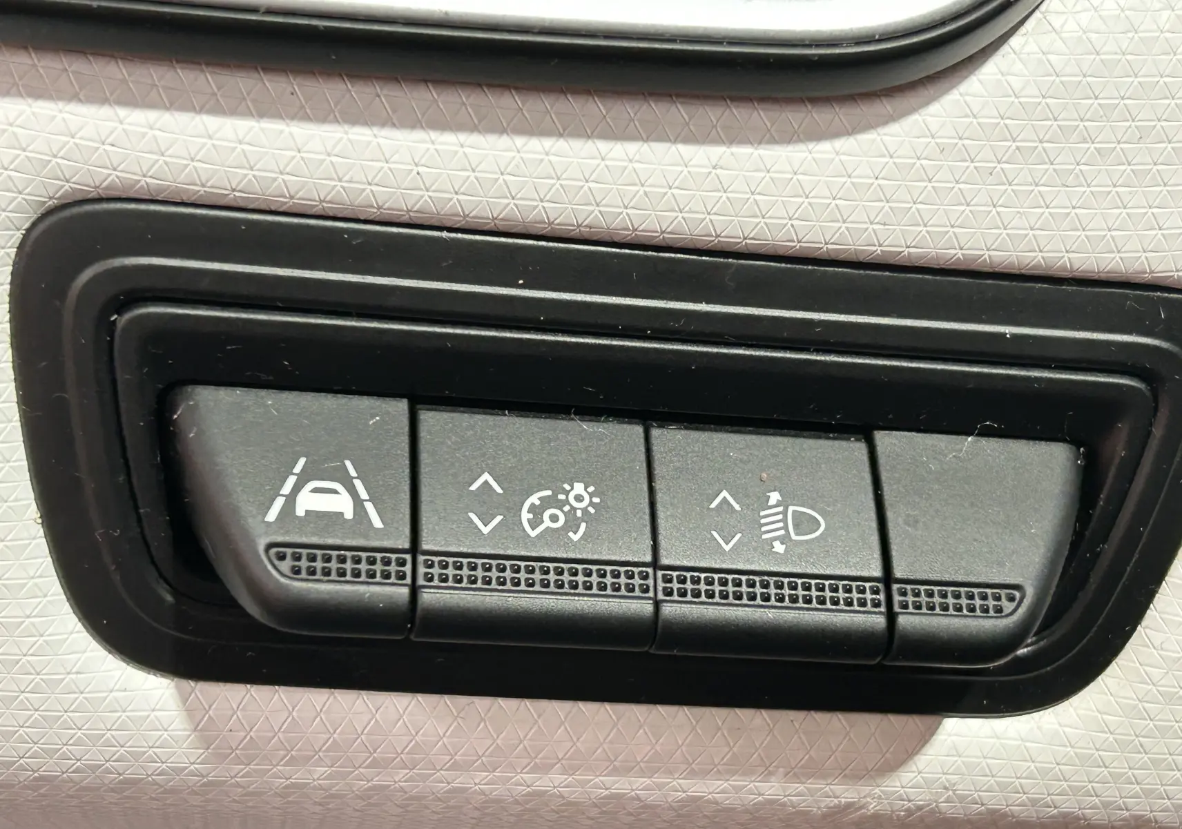 Boutons de réglage d'assistance à la conduite et d'éclairage sur tableau de bord de Renault Clio V rouge vue intérieure.