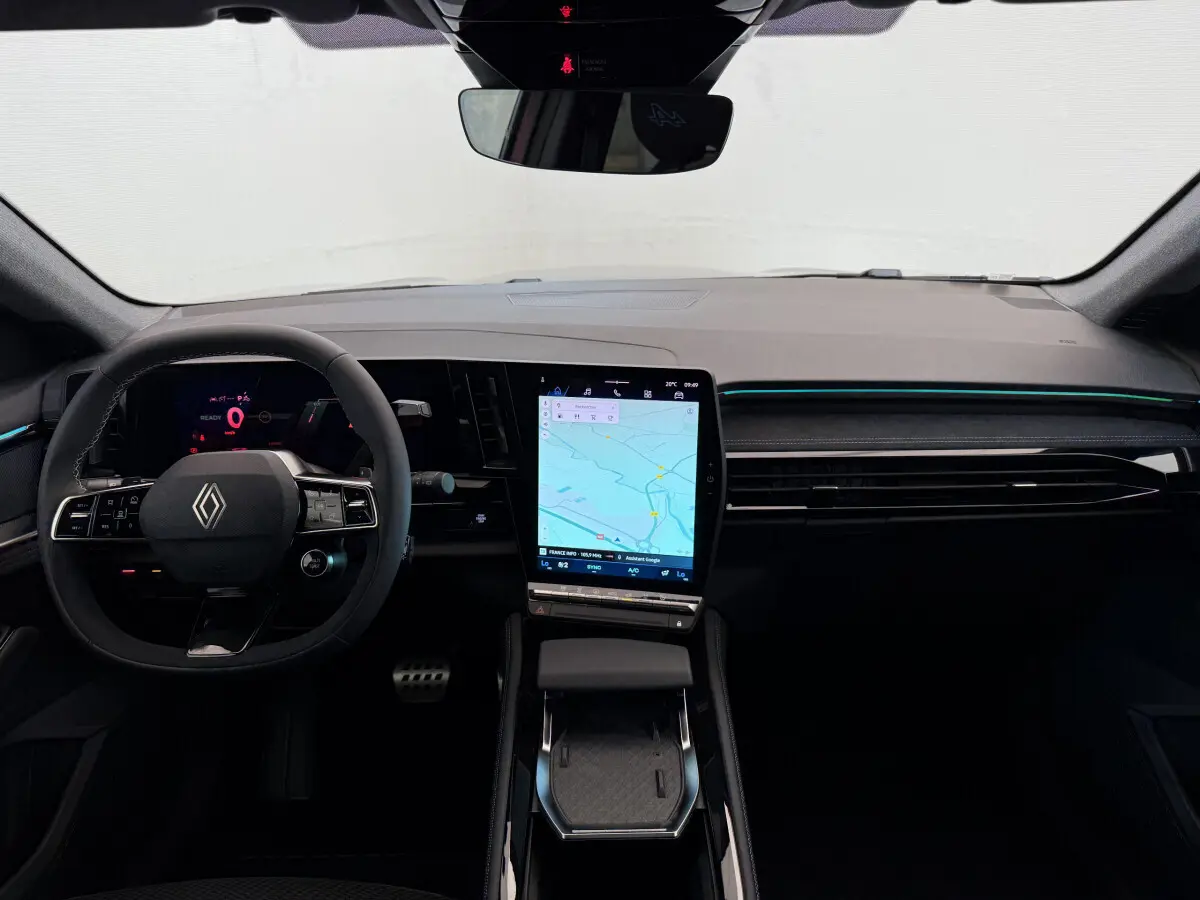 Intérieur avant du Renault Espace Esprit Alpine 2025, tableau de bord noir avec grand écran tactile central affichant la navigation.