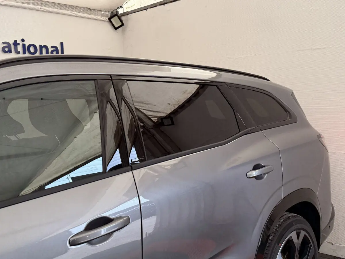 Vue latérale côté droit du Renault Espace gris foncé esprit Alpine avec vitres teintées et jantes noires.