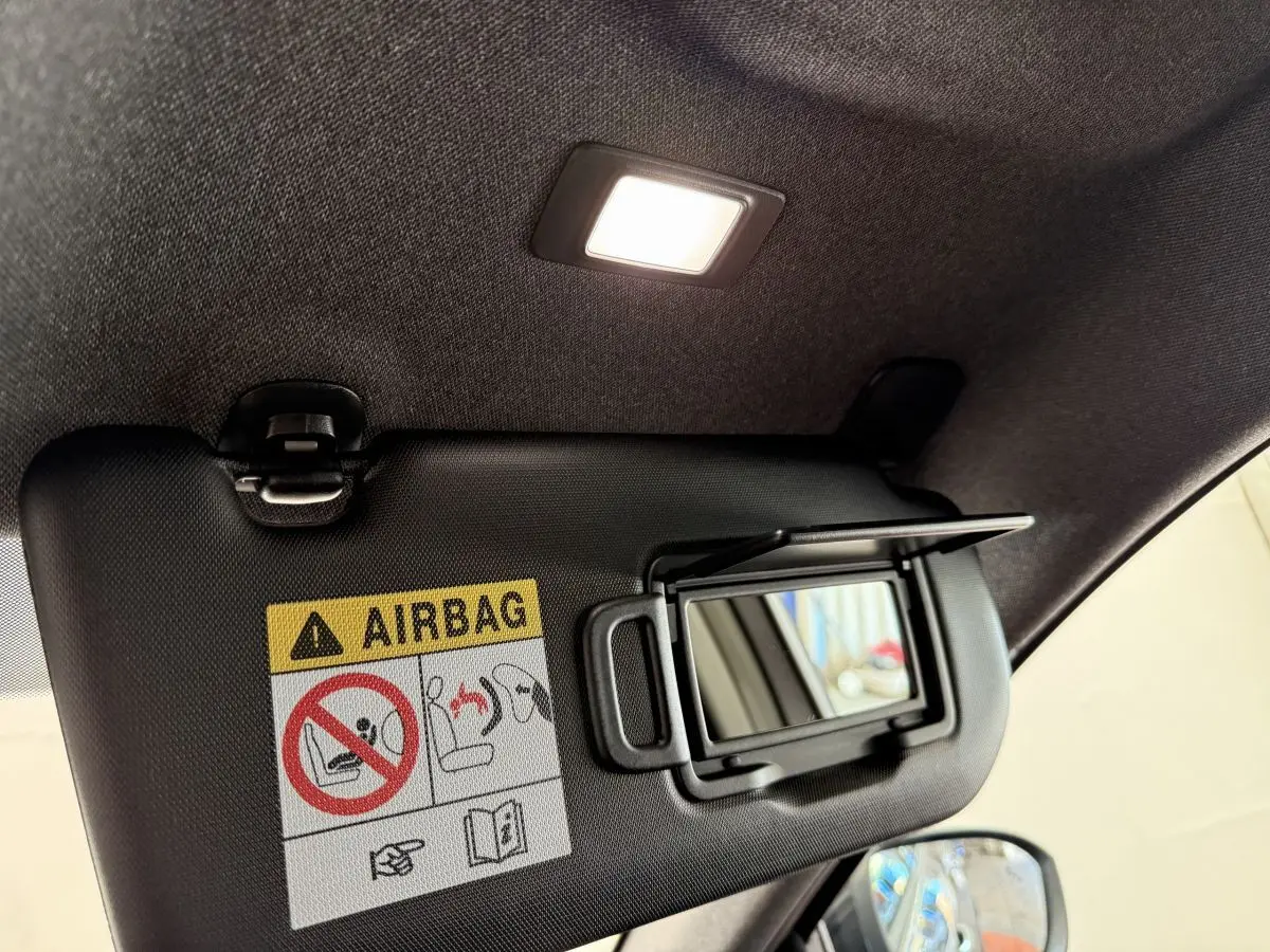 Détail du pare-soleil côté conducteur avec miroir éclairé et avertissement airbag dans un Renault Espace gris foncé 2025.