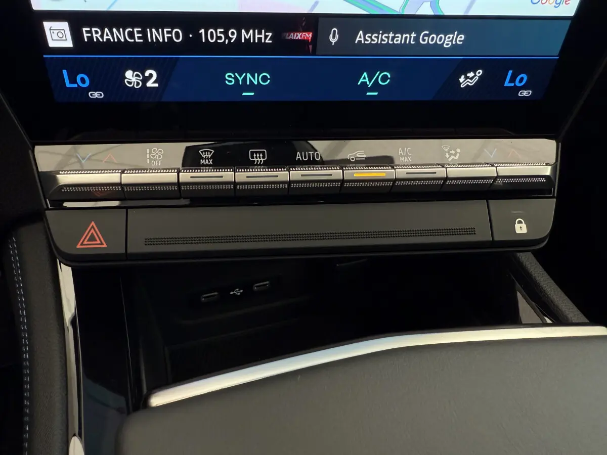 Gros plan sur la console centrale tactile du Renault Espace gris foncé, mettant en valeur les commandes climatisation et ports USB.