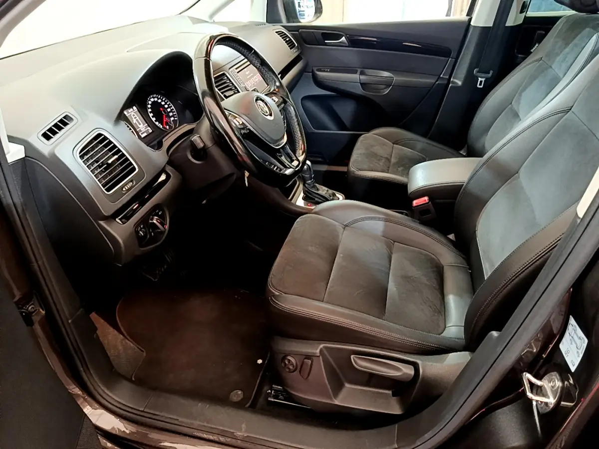 Intérieur avant droit du Volkswagen Sharan marron 2017, montrant sièges cuir et tableau de bord avec volant multifonctions.